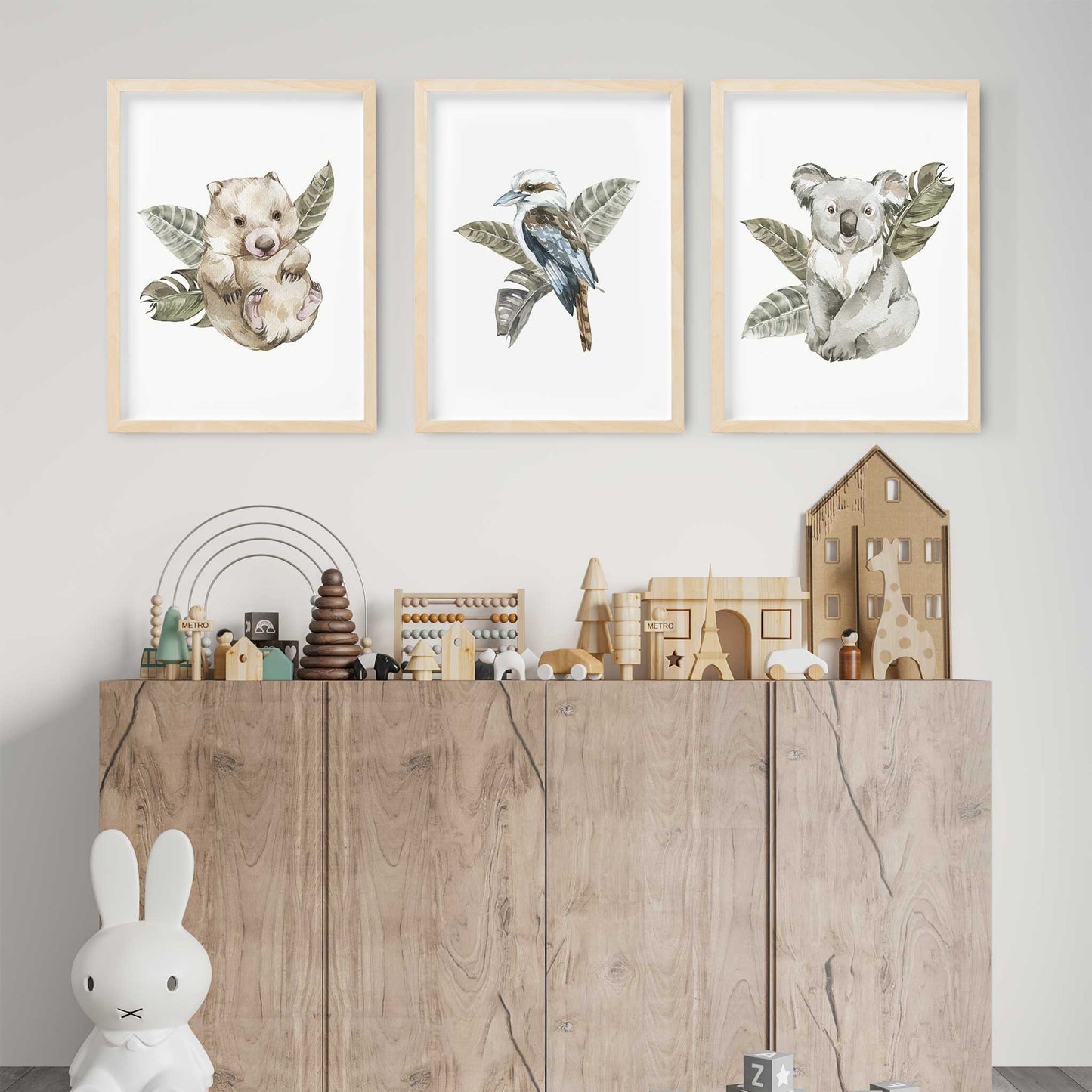 A set of 3 wall oak framed images of Australia animals wombat, kookaburra and koala displayed on the wall of a kids playroom