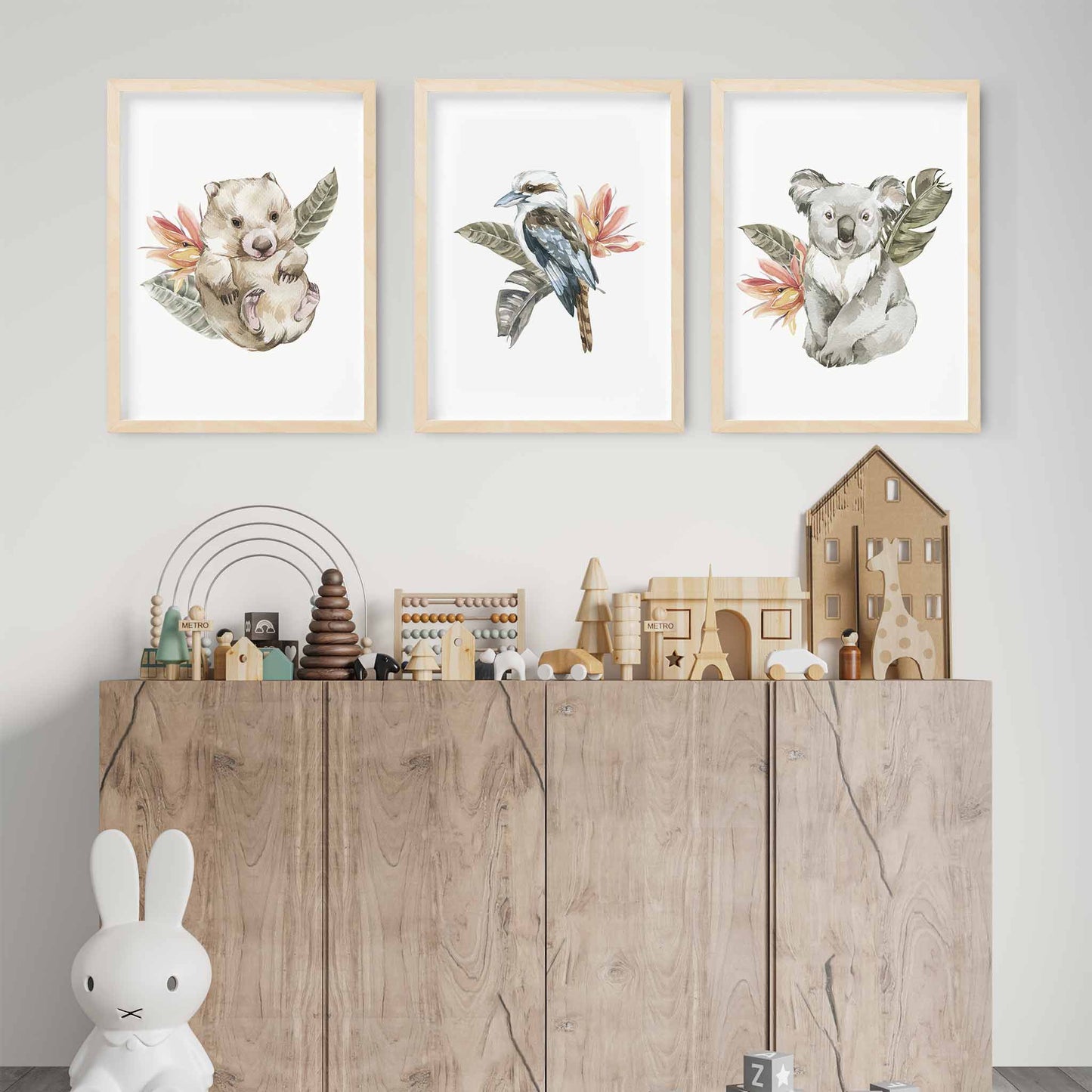 A set of 3 wall oak framed images of Australia animals wombat, kookaburra and koala displayed on the wall of a kids playroom