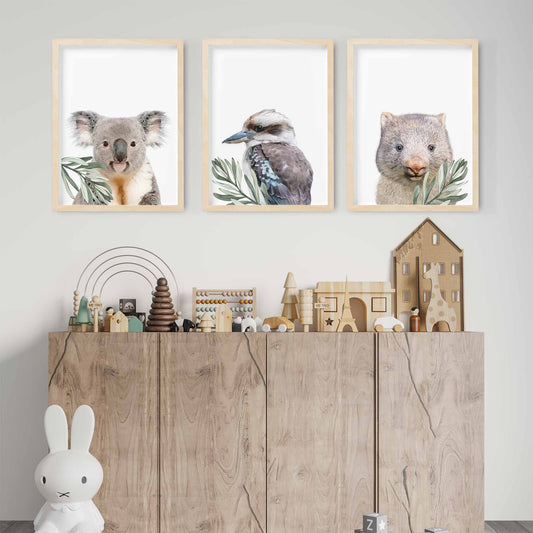 A set of 3 wall oak framed images of Australia animals wombat, kookaburra and koala displayed on the wall of a kids playroom