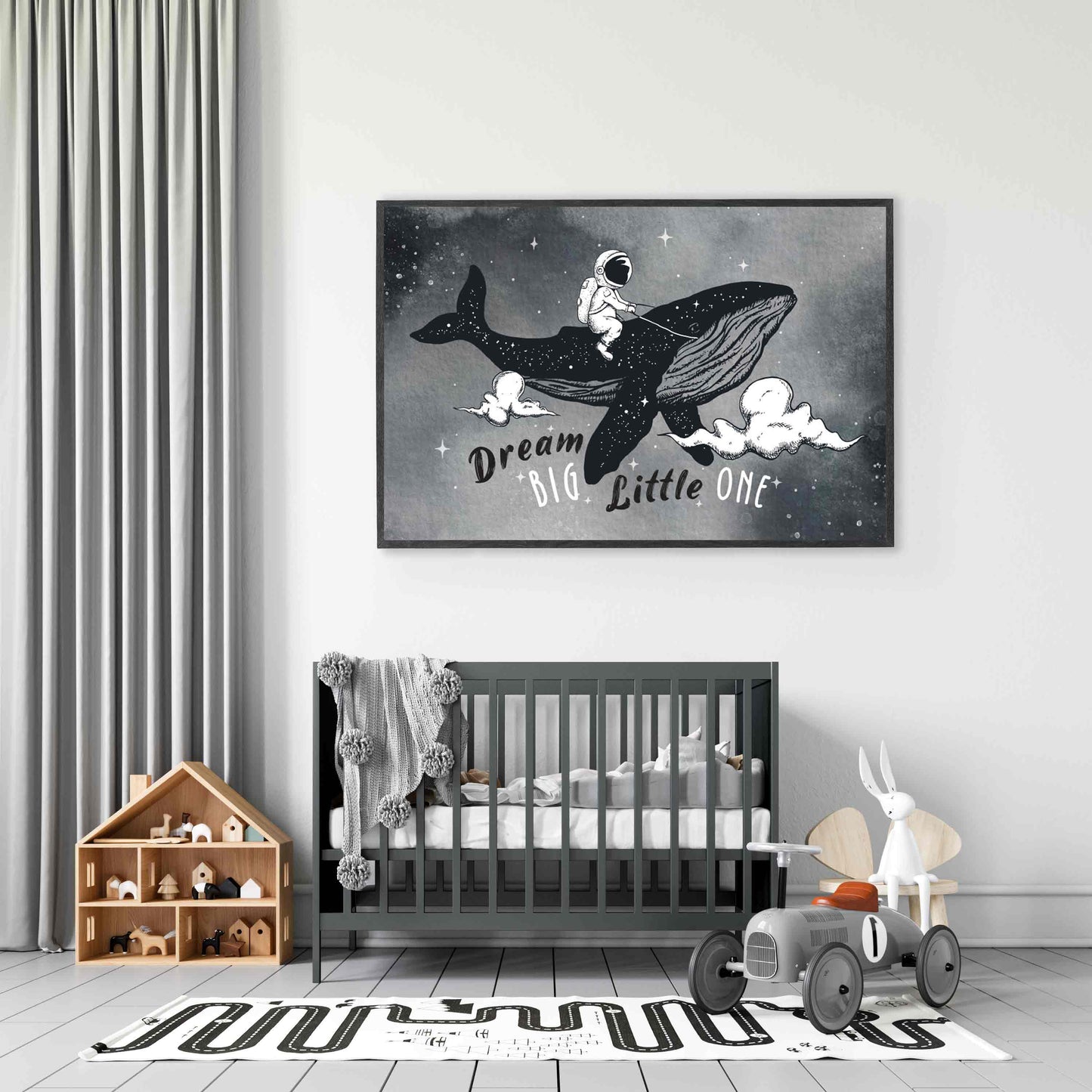 A black frame picture of a kids space aspirational poster print featuring an astronaut riding a whale in the night sky hung in a nursery room