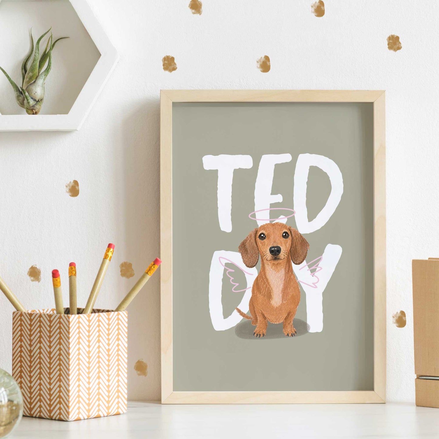 Framed kids pet portrait artwork with a dachshund illustration and 'Teddy' text on a light green background.