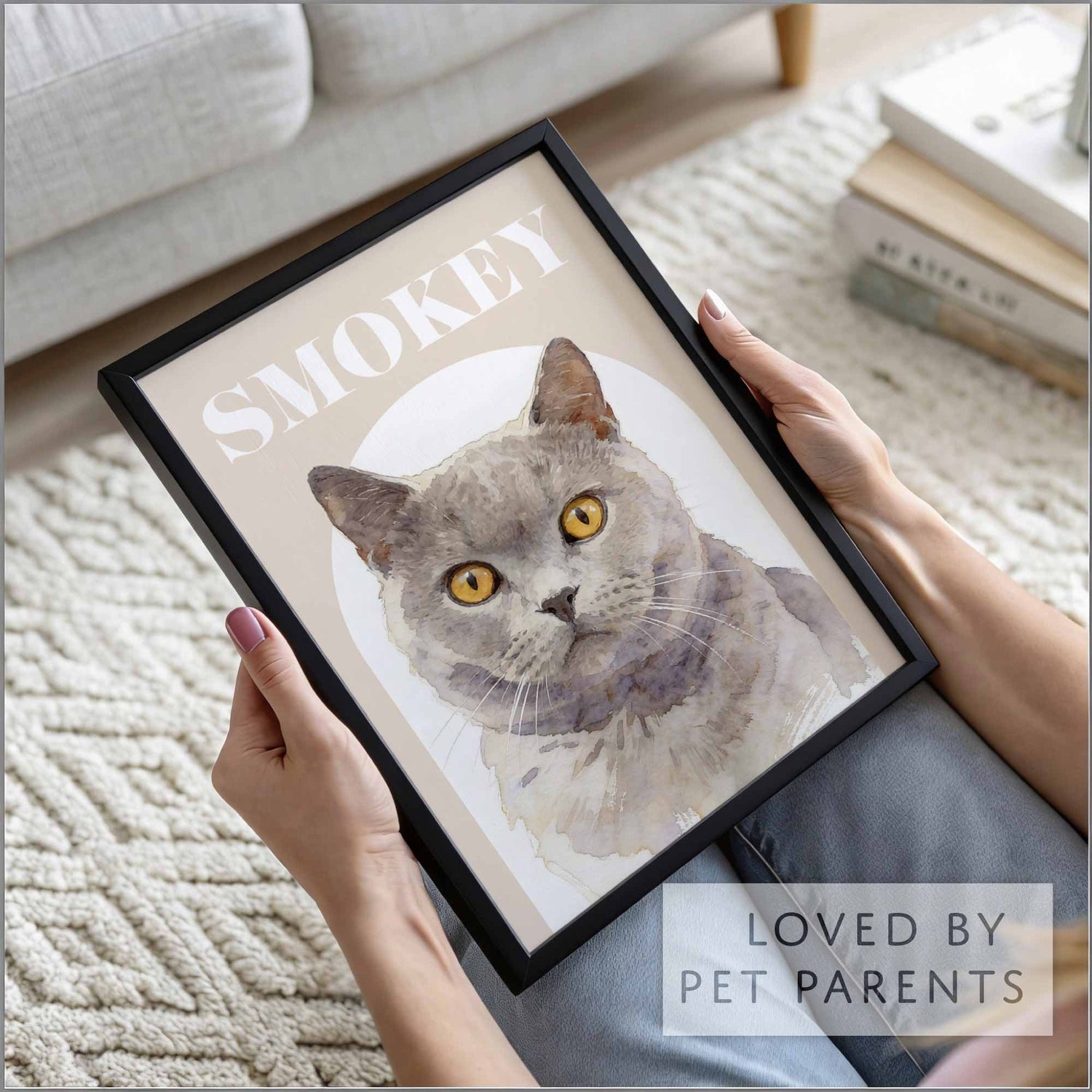 Framed picture of a cat portrait named Smokey held by a person in a home setting.