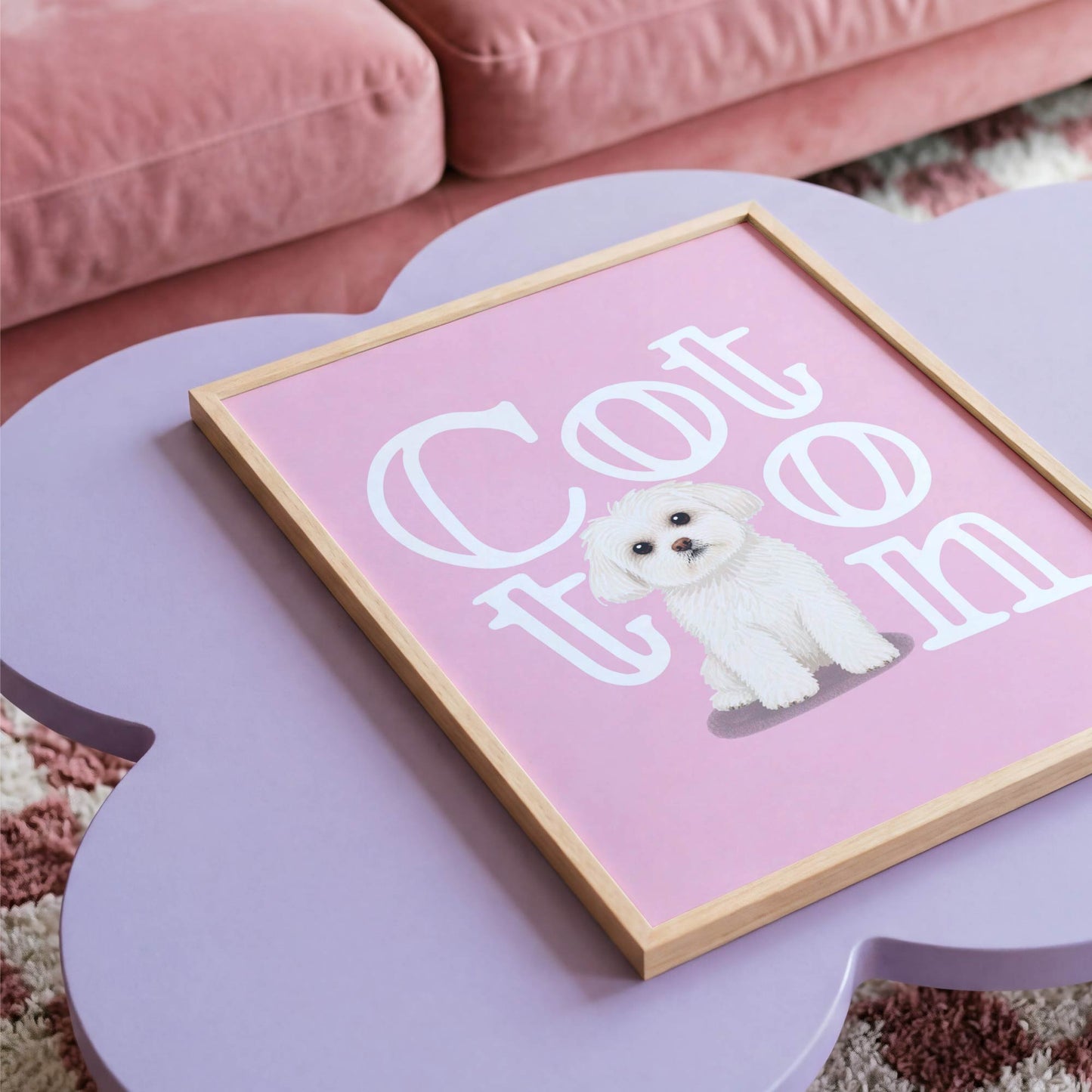 Framed kids pet portrait  of a white dog on a pink background with 'Cotton' text, placed on a pink surface.