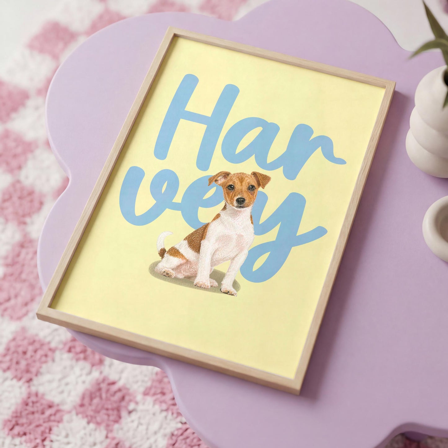 Framed kids pet portrait of a dog with 'Harvey' written on it, placed on a pink surface.