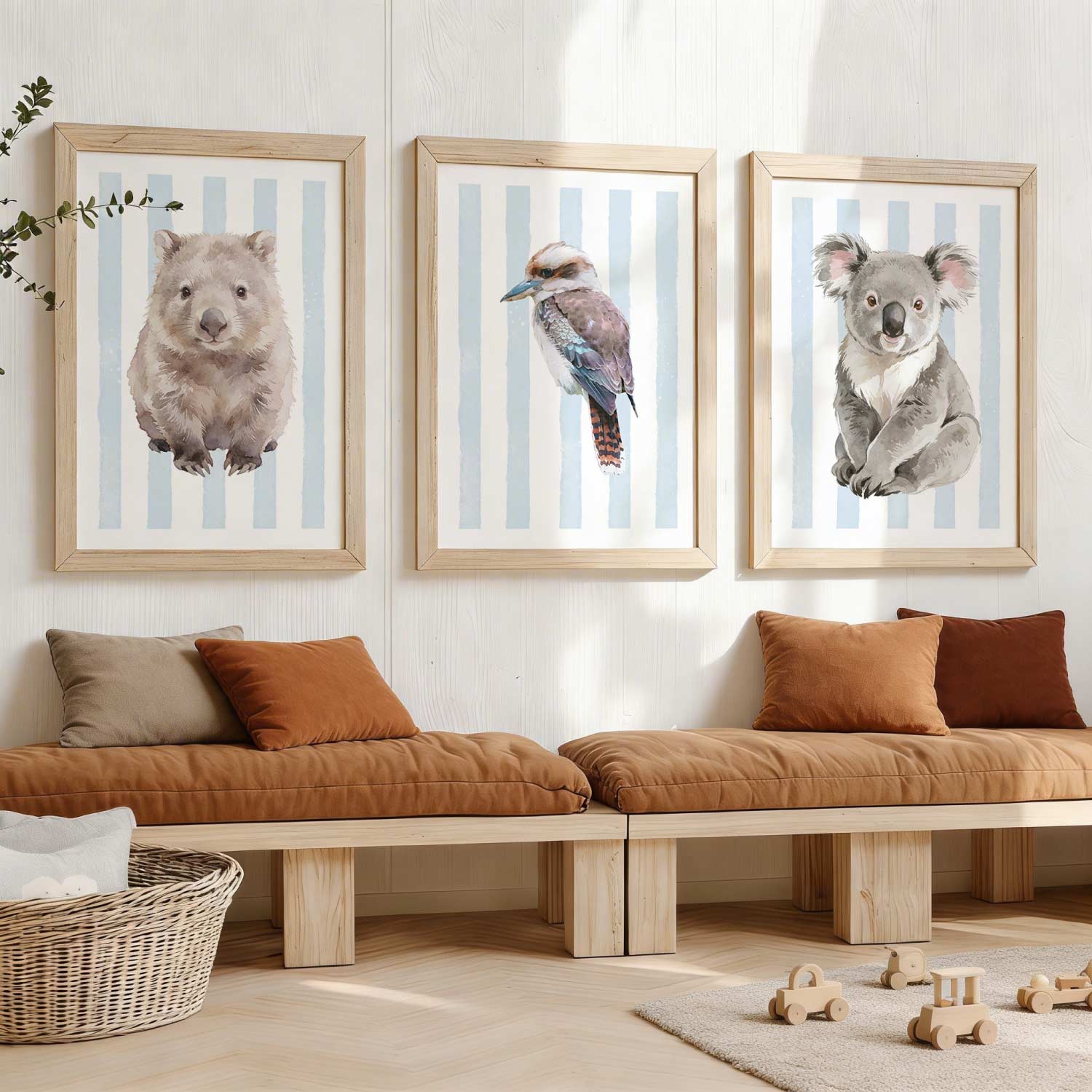 Framed Australia animal prints on a striped blue background on a wall above a wooden bench with cushions.