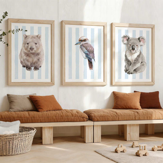 Framed Australia animal prints on a striped blue background on a wall above a wooden bench with cushions.
