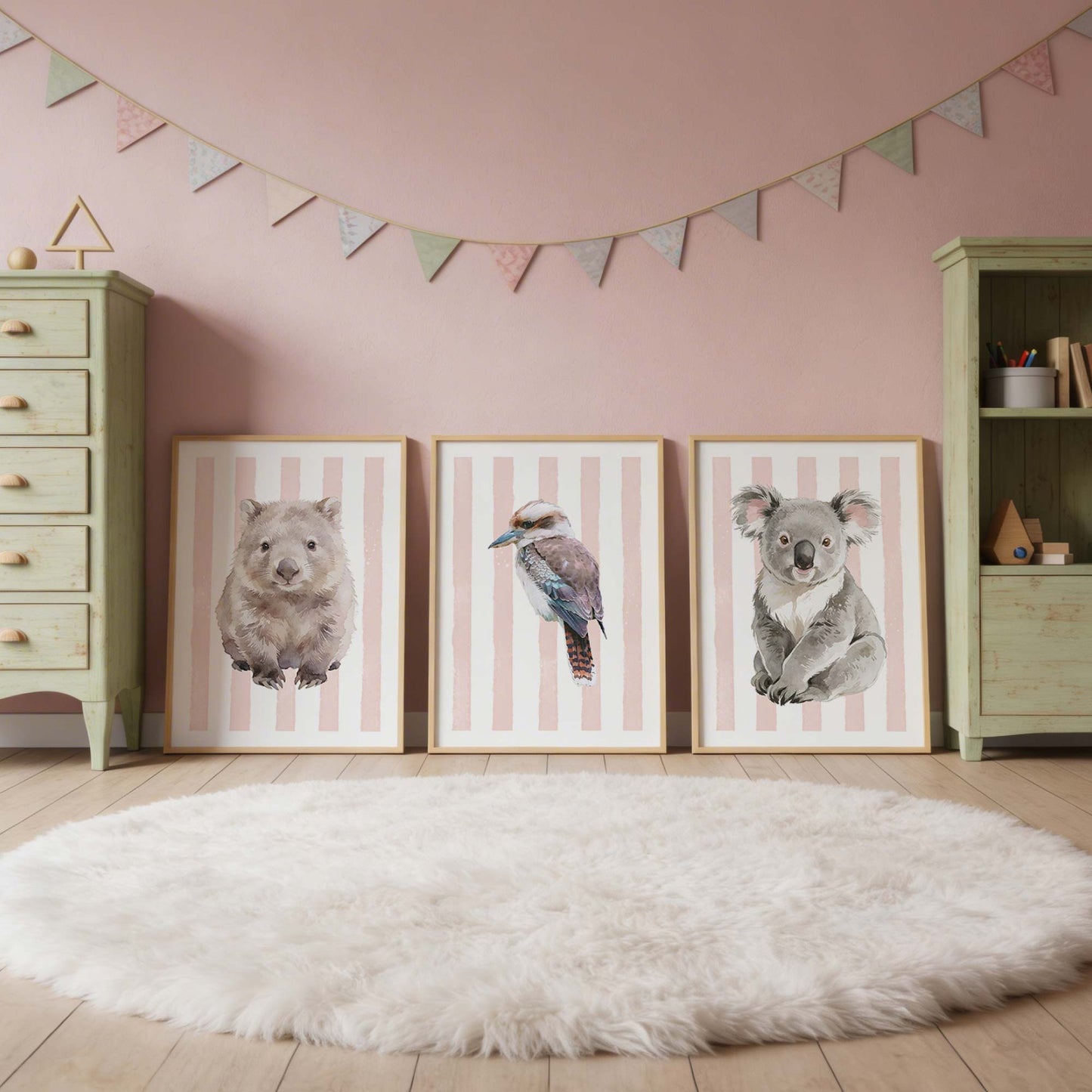 Three framed Australia animal prints on pink stripes background on a wall with a pink background and decorative flags.