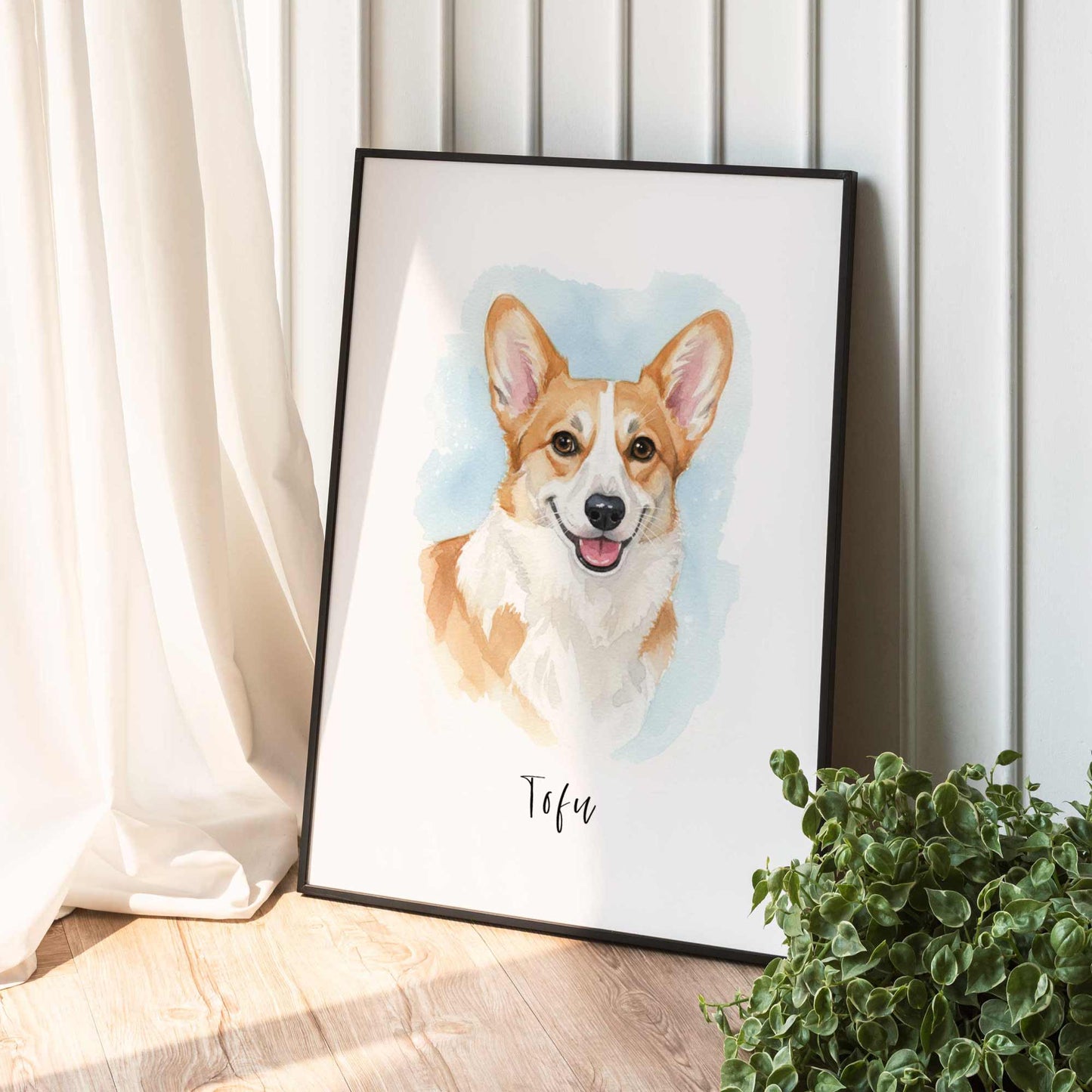 Framed artwork of a corgi dog named Tofu on a white wall with a plant in the foreground.