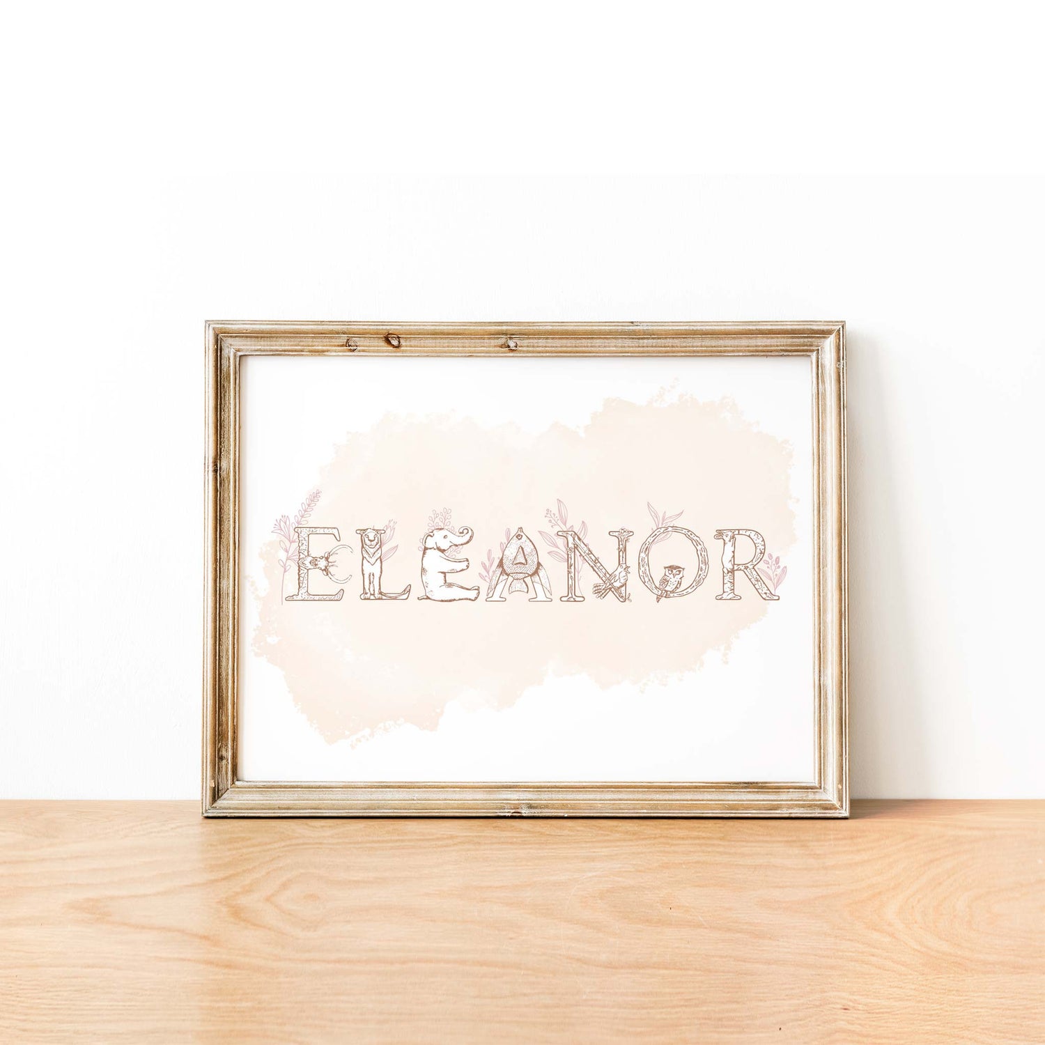 An oak picture frame of a animal alphabet shape name print in pink watercolour background 