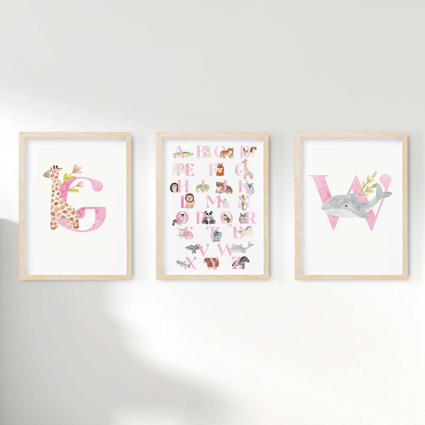 A set of 3 oak picture frames of pink monogram prints and alphabet shape animal chart