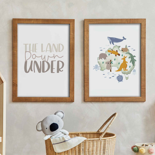 Two framed wooden frames of the land down under print and Australia animal map print displayed on the wall of a kids bedroom