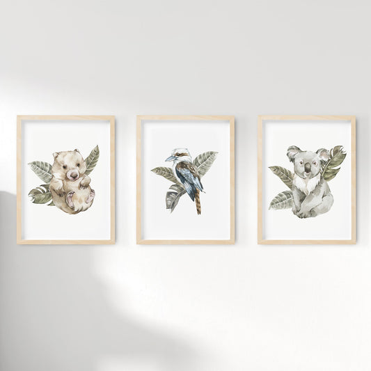 A set of 3 framed oak frames displaying kids nursery wall prints of Australian wombat, kookaburra and koala with leaves background