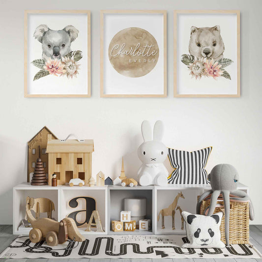 A set of 3 wall oak framed images of Australian wombat and koala featuring a personalised kids name plaque in a child's  playroom  