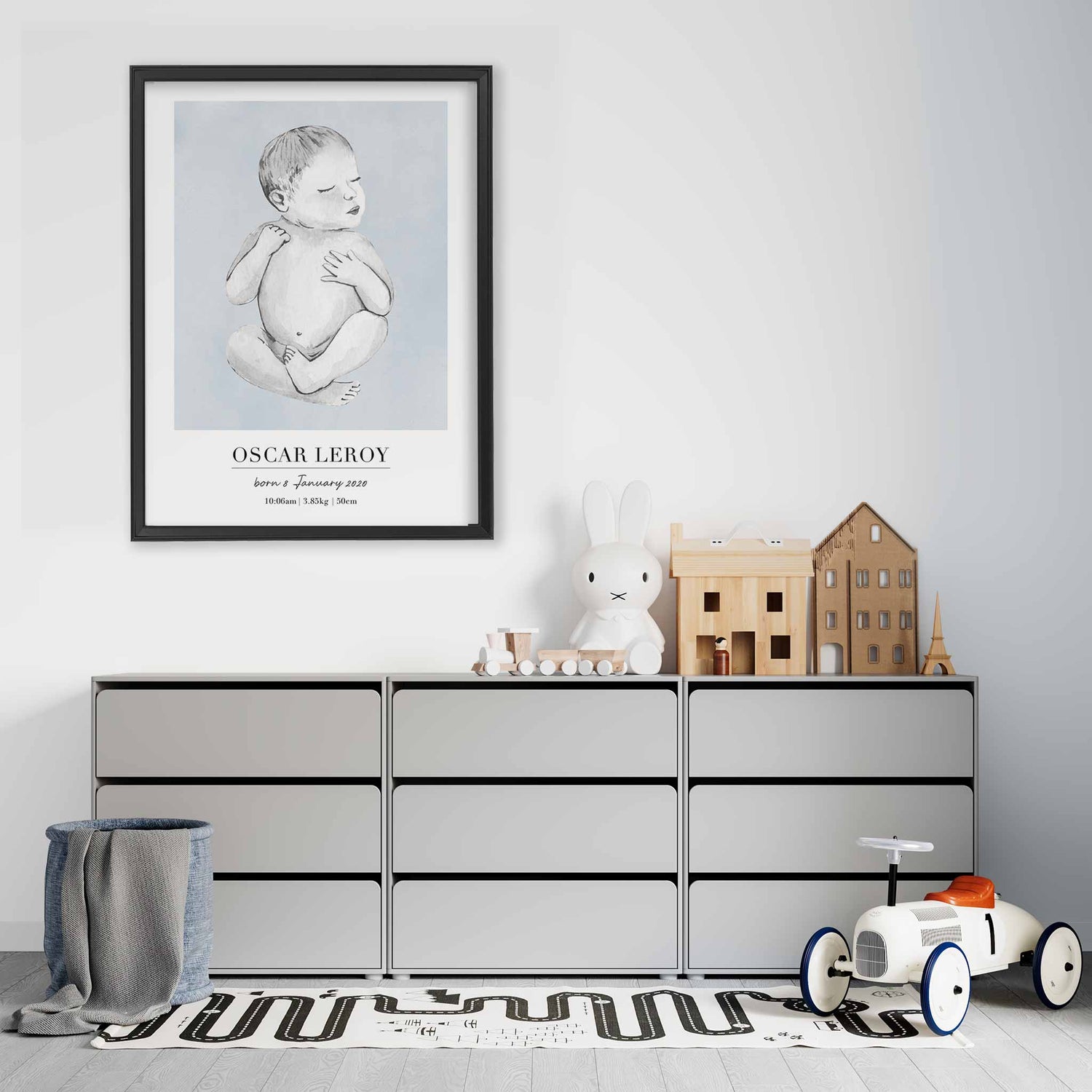 A black picture frame of a baby boy personalised birth poster print decorated in a living room