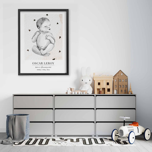 A black picture frame of a baby boy personalised birth poster print decorated in a living room