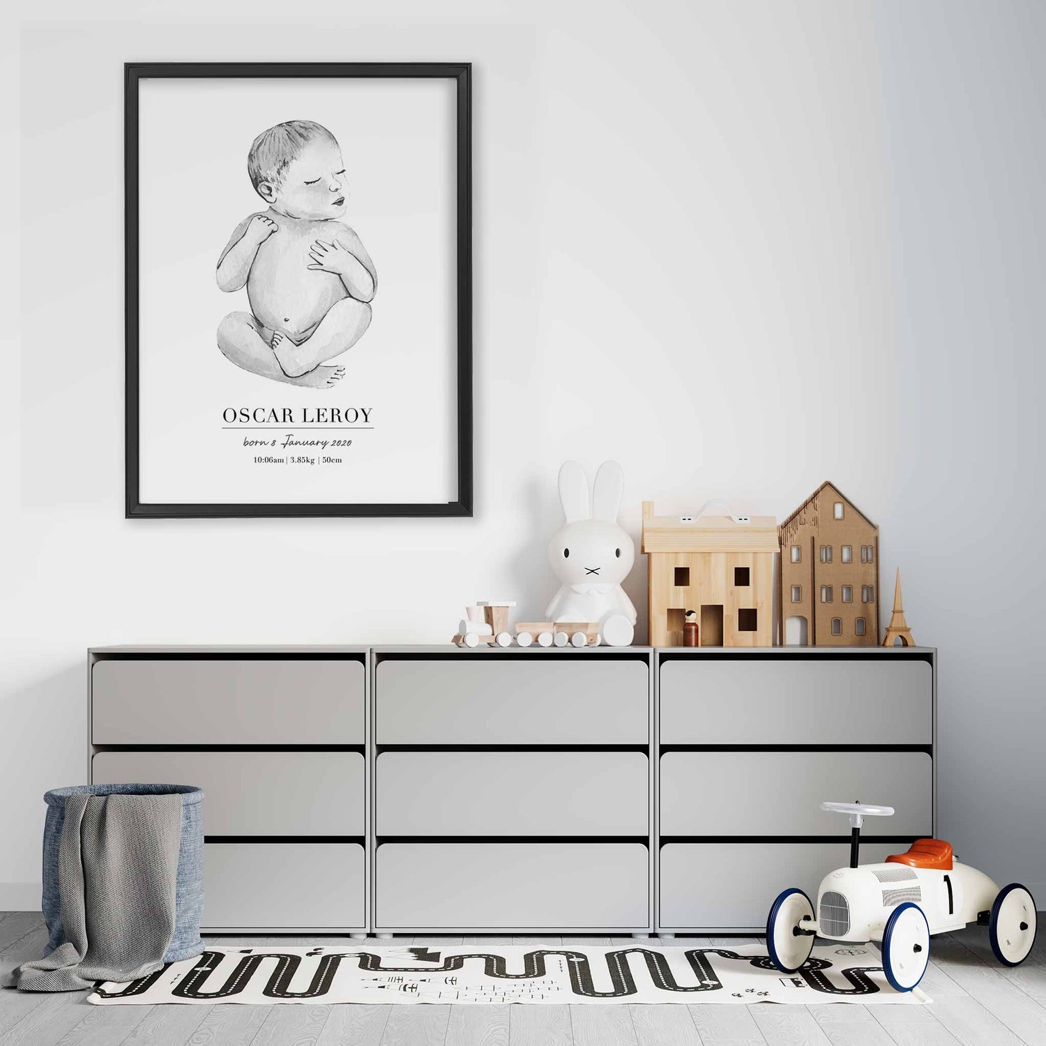 A black picture frame of a baby boy personalised birth poster print decorated in a living room