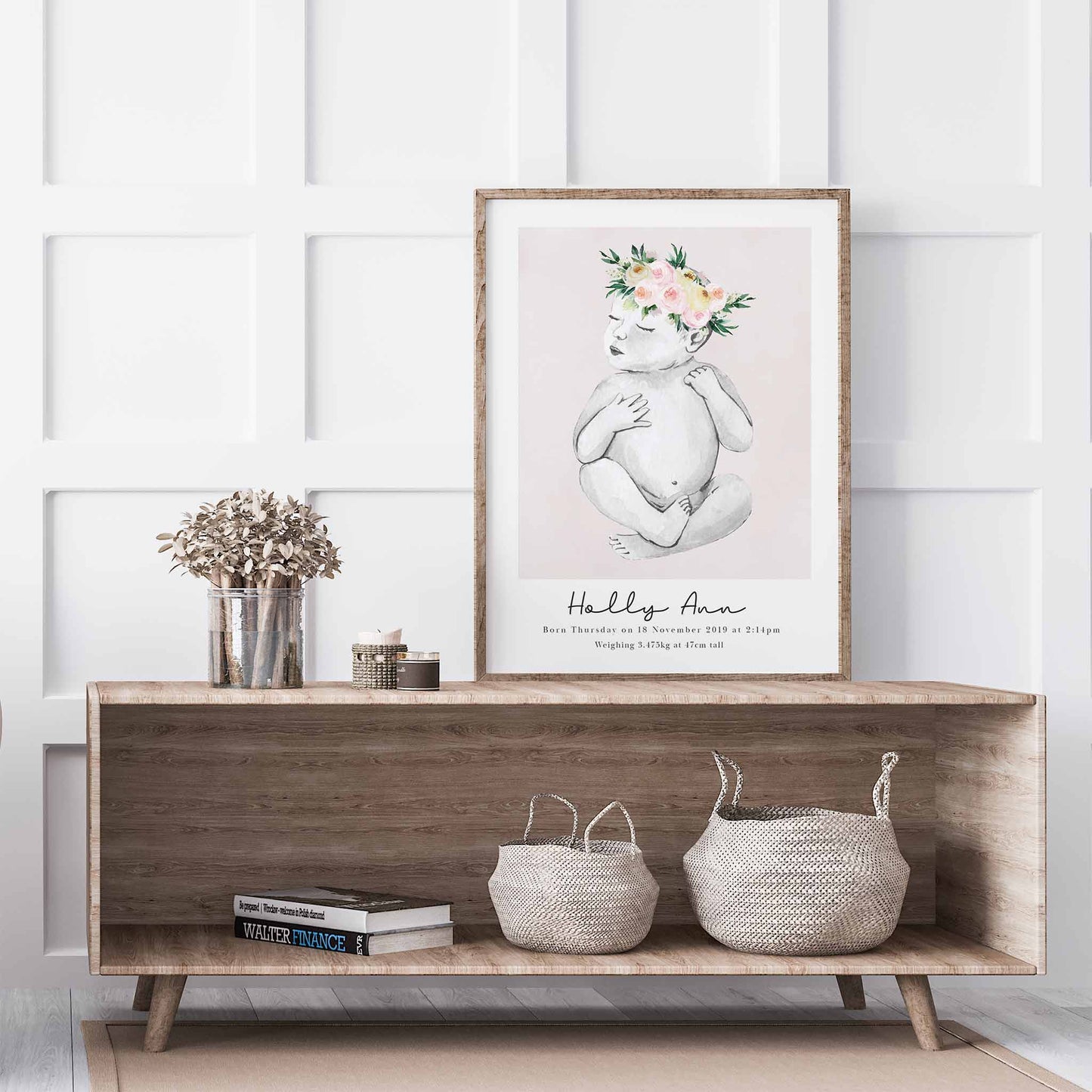 An oak picture frame of a baby girl personalised birth poster print decorated in a living room