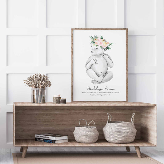 An oak picture frame of a baby girl personalised birth poster print  decorated in a living room