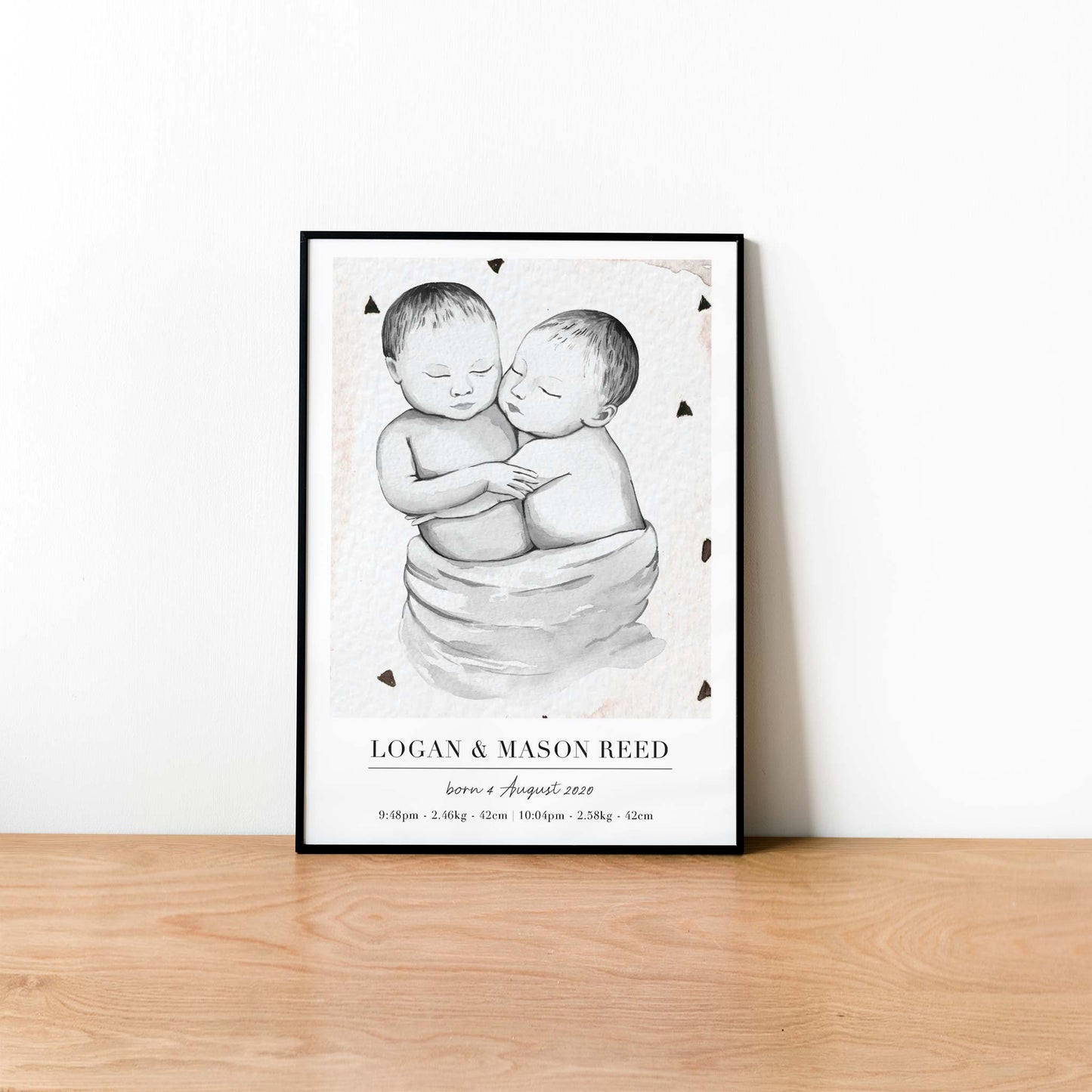 A black picture frame of a baby twin boys personalised birth poster print