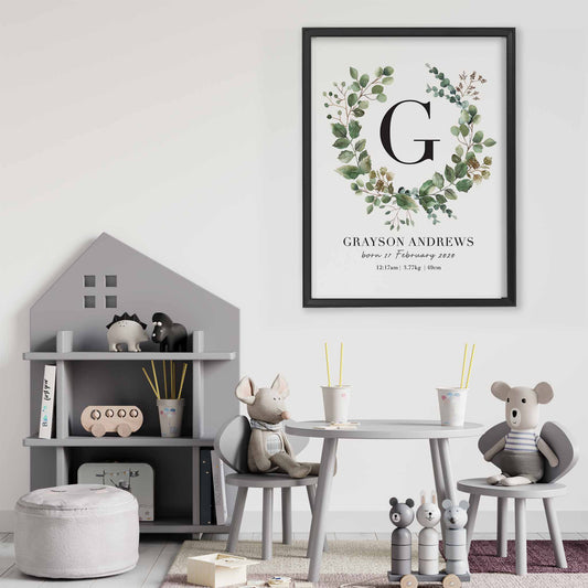 A black picture frame of a botanical wreath monogram personalised birth print decorated in a playroom