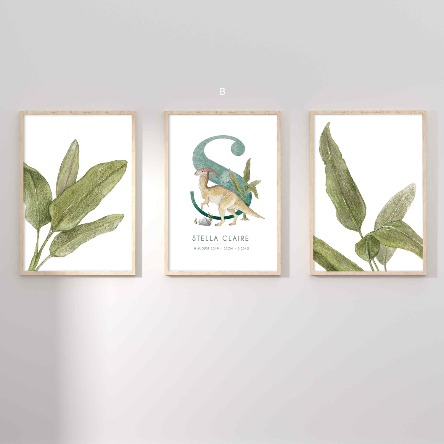 A set of 3 framed oak frames displaying kids nursery wall prints of palm leaves and a dinosaur personalised monogram birth print