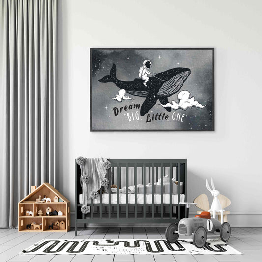 A black frame picture of a kids space aspirational poster print featuring an astronaut riding a whale in the night sky hung  in a nursery room