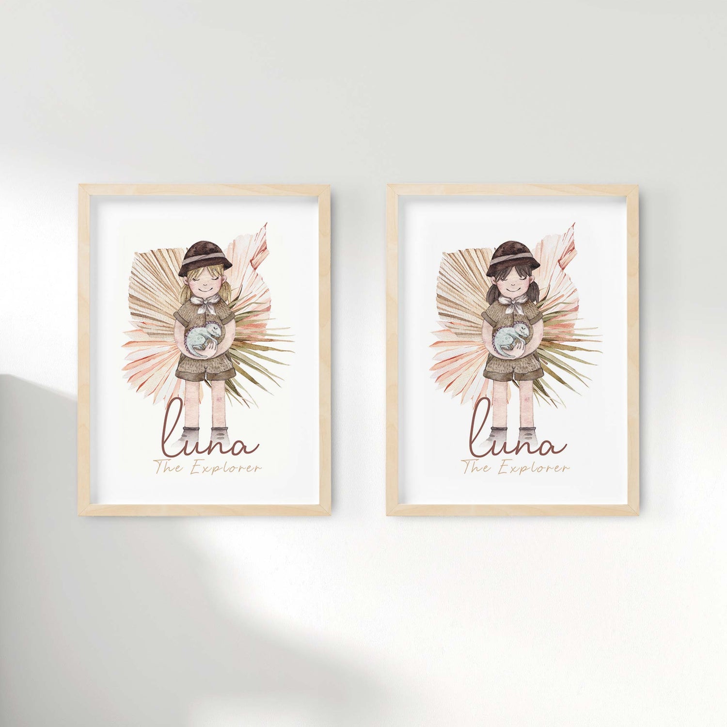 A set of 2 picture frames displaying kids name print of a little girl holding a baby dinosaur