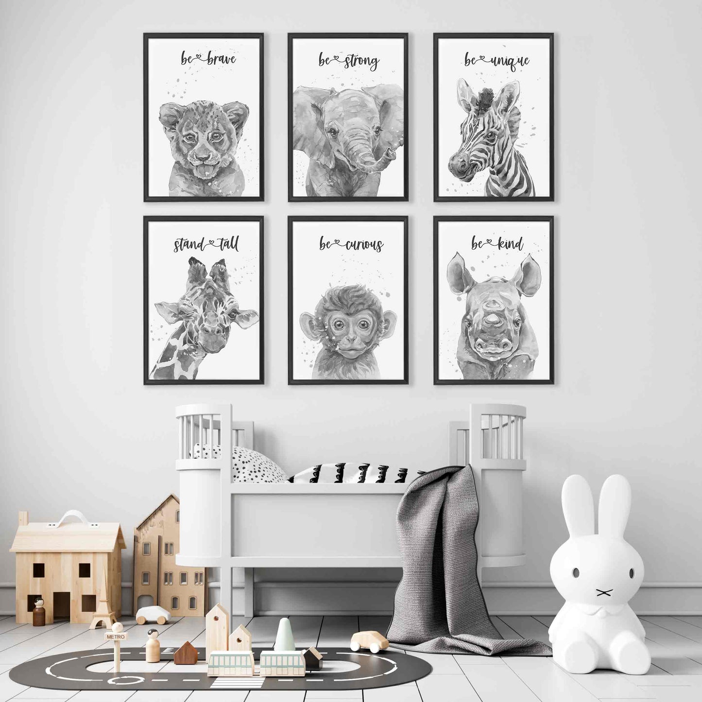 A set of six black picture frames of monochromatic safari animals aspirational print decorated in a nursery