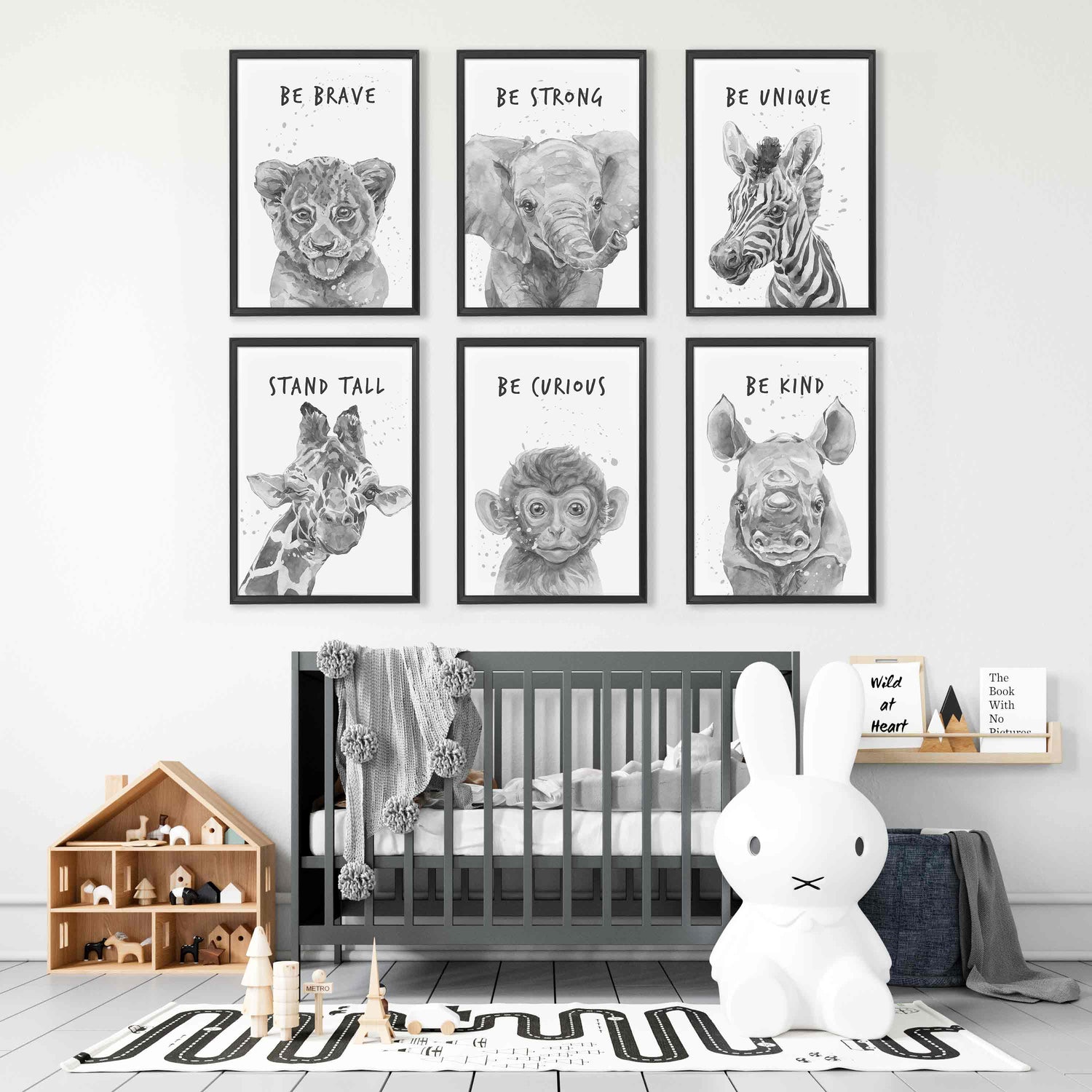 A set of six black picture frames of monochromatic safari animals aspirational print decorated in a nursery