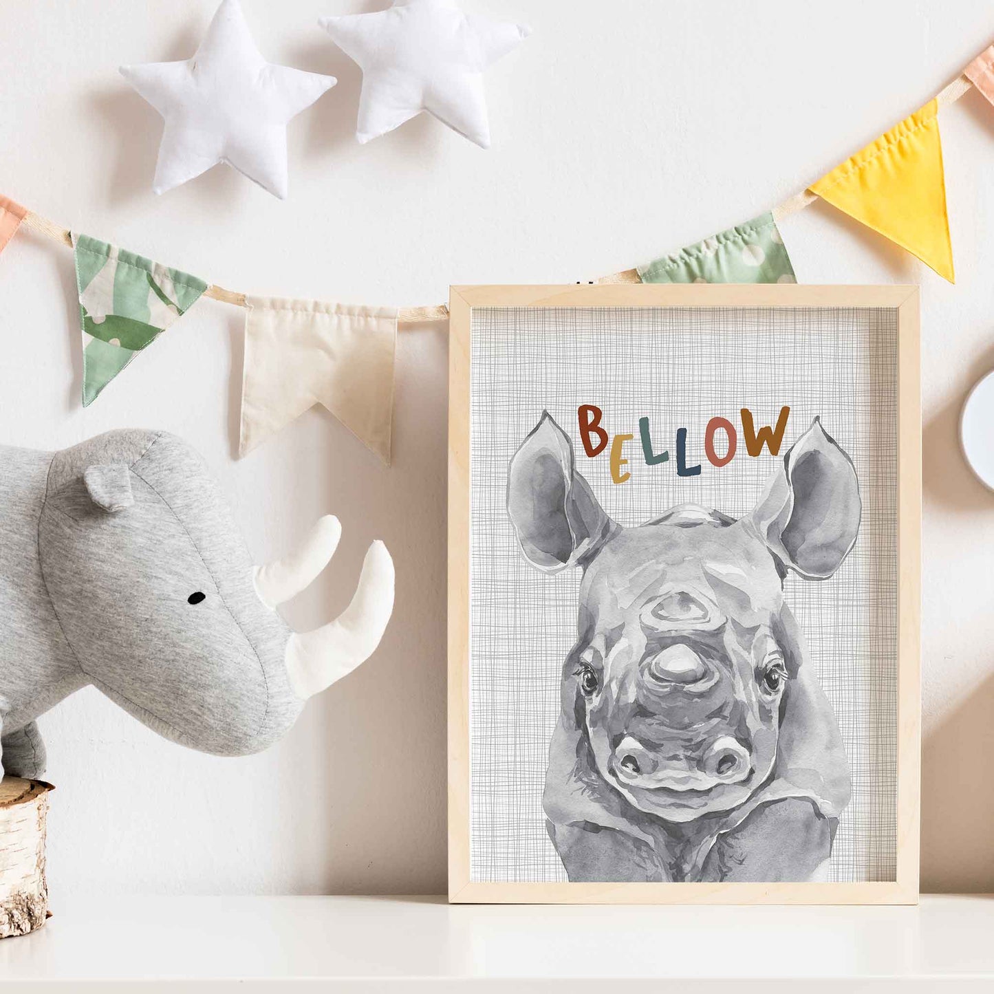 An oak picture frame of a cute watercolour baby rhino decorated in a kids room