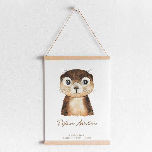 A hanging frame of a watercolour otter kids personalised birth print