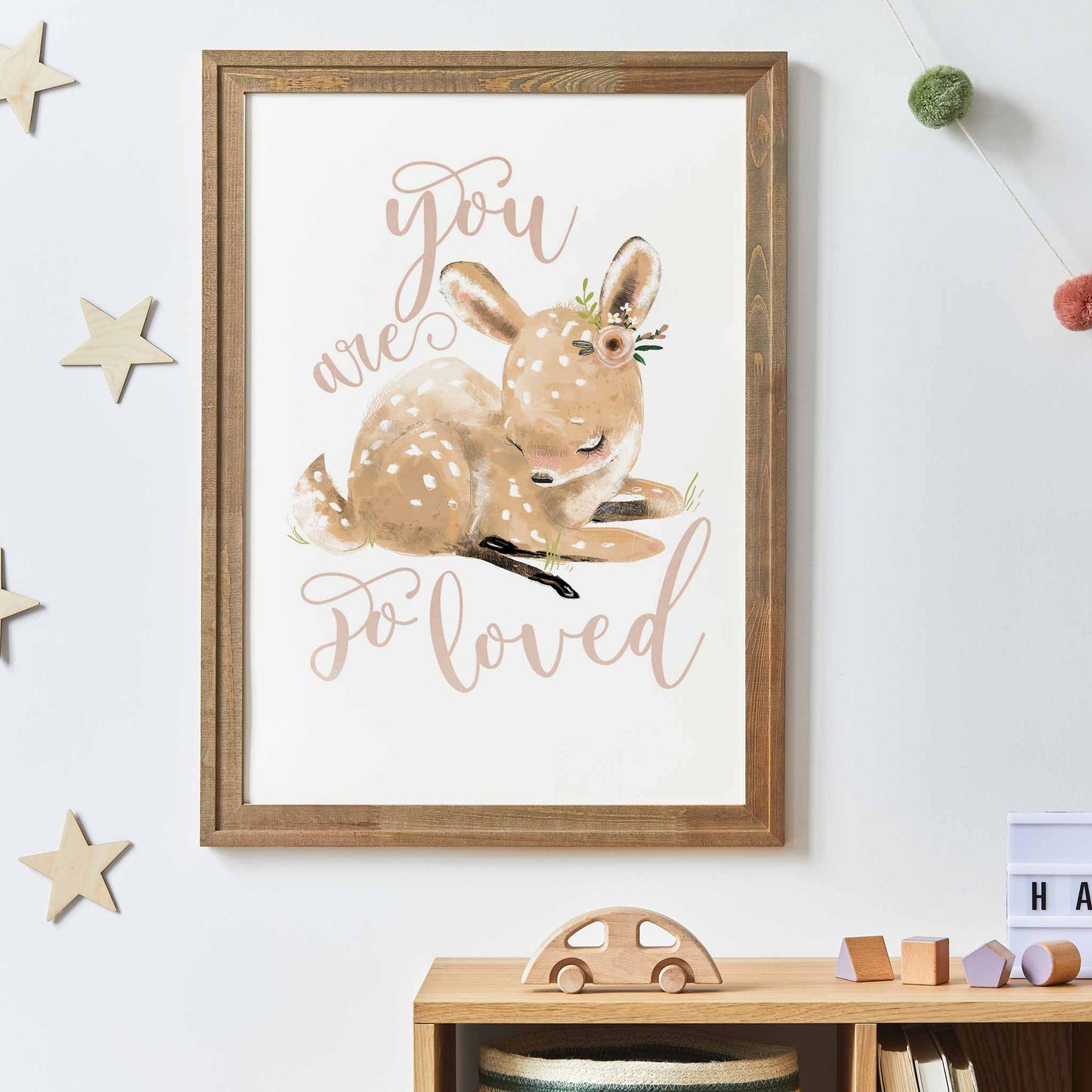 An oak frame of a cute whimsical deer with inspirational quote decorated in a kids room